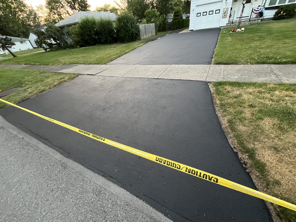 Completed asphalt sealcoating job on a Gates, NY driveway by Bold Seal